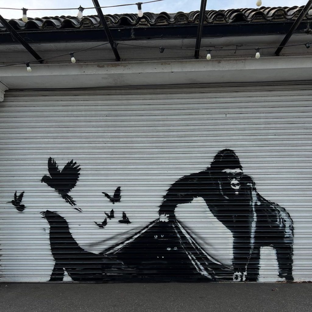 Gorilla lifting zoo shutters in the Banksy London Zoo 2024 finale at London Zoo