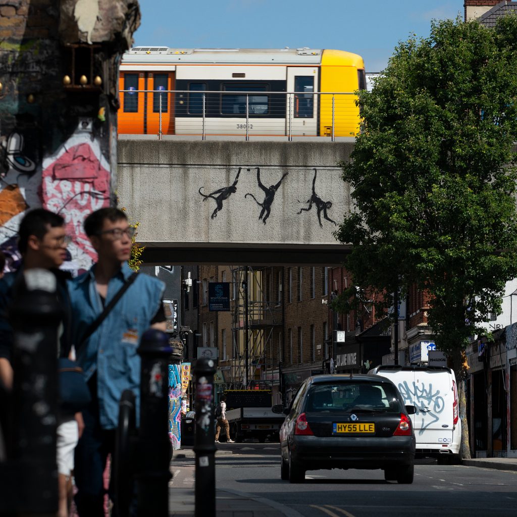 Three monkeys stencil over Brick Lane bridge from the Banksy London Zoo 2024 trail