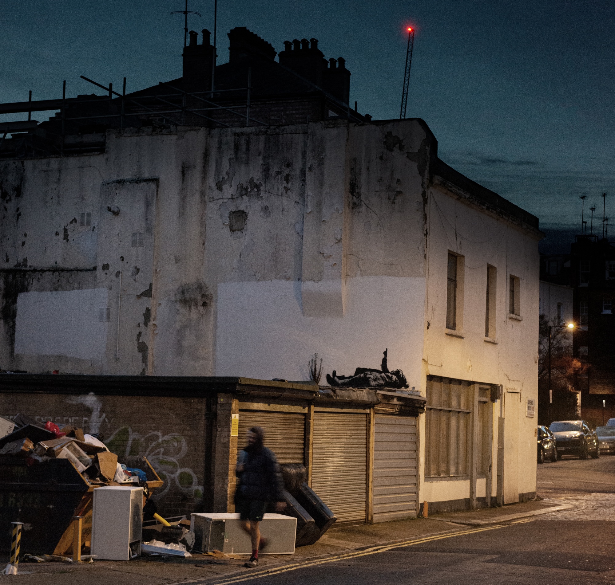 Banksy Christmas mural in Queens Mews aligning children’s gesture with a red star light