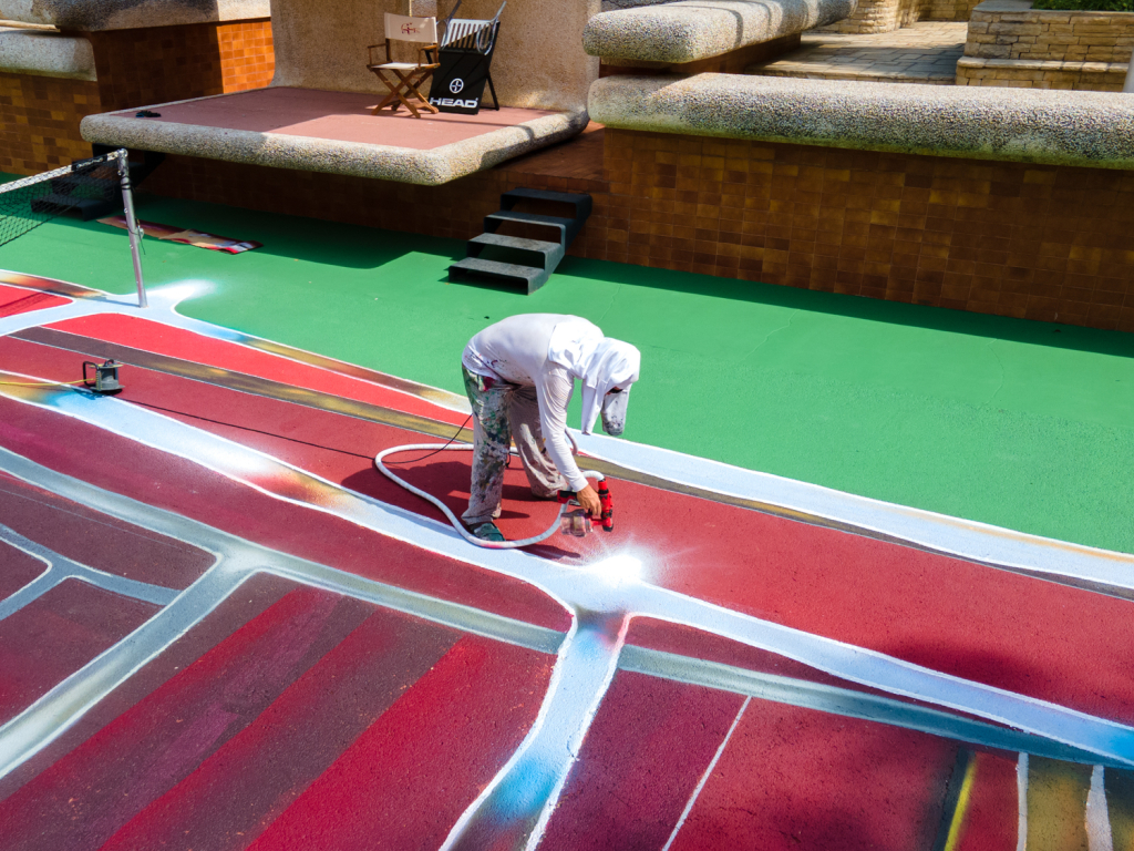 Spok Brillor using spray equipment to build the highlights and colour transitions of Hard Court 2 at Casa Axis.